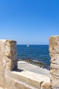 View through the battlements of the Firka Venetian Fortress on a sailing ship sailing on the sea of Ã¢â¬â¹Ã¢â¬â¹Crete near Chania, Crete Royalty Free Stock Photo